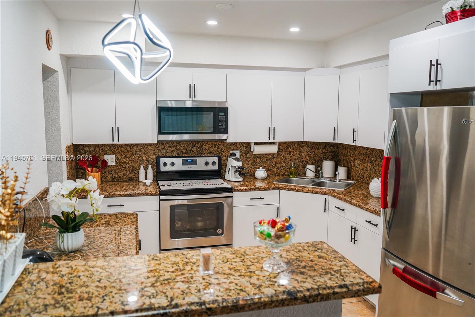 1190 West 33rd Street Hialeah, FL 33012 - Photo 16 of 54 a kitchen with stainless steel appliances granite countertop a stove a sink and a microwave