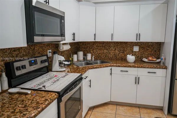 a kitchen with stainless steel appliances granite countertop a refrigerator and a stove
