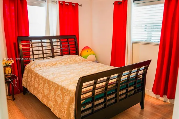 a bedroom with a bed and wooden floor
