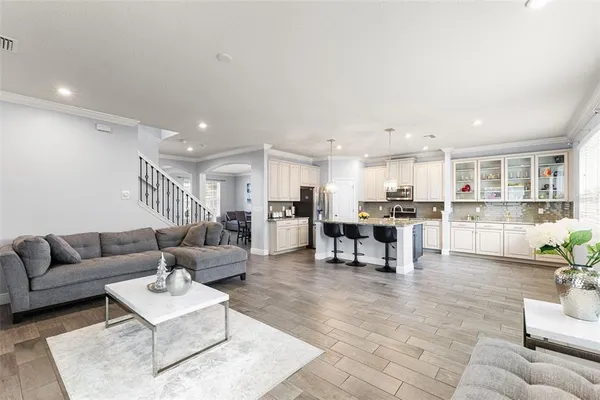 a kitchen with granite countertop kitchen island stainless steel appliances a sink and a refrigerator