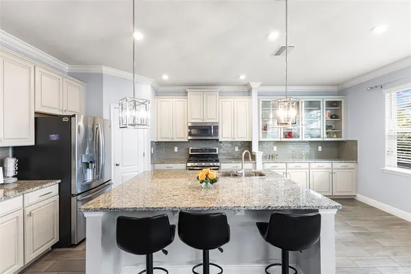 a kitchen with stainless steel appliances granite countertop a sink stove and refrigerator