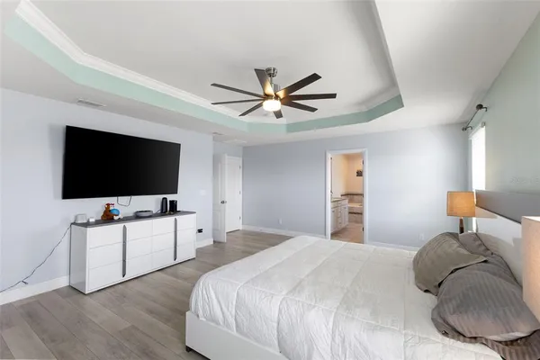 a bedroom with a large bed chandelier and a window
