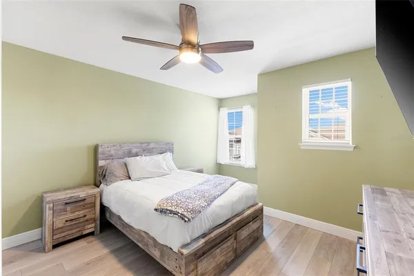 a bedroom with a bed a chandelier and a window