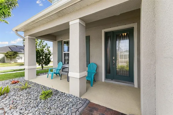 a view of a porch with chairs and backyard