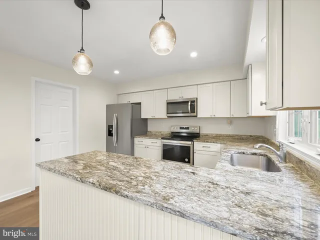 a kitchen with stainless steel appliances granite countertop a sink refrigerator and microwave