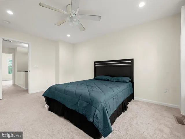 a bedroom with a bed and ceiling fan