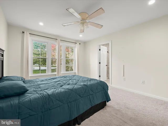 a bed sitting in a spacious bedroom next to a window
