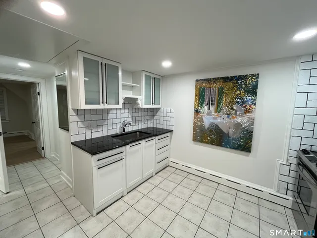 a kitchen with granite countertop a sink and a stove top oven