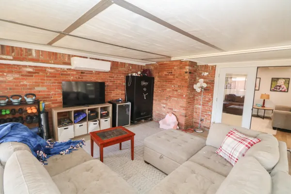 a living room with furniture a flat screen tv and a table