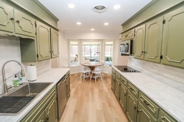 a kitchen with stainless steel appliances granite countertop sink stove top oven and cabinets