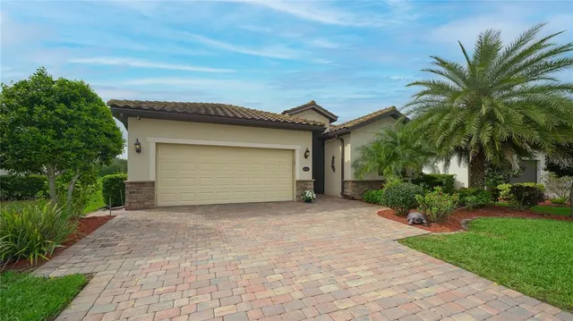 a backyard of a house with potted plants and palm trees
