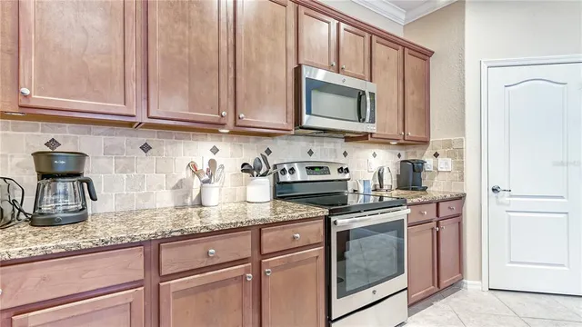 a kitchen with granite countertop stainless steel appliances white cabinets granite counter tops and a wooden floors