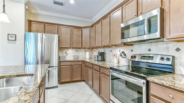 a kitchen with stainless steel appliances granite countertop a refrigerator stove and sink