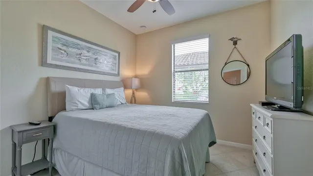a bedroom with a bed and a flat tv screen on the dresser