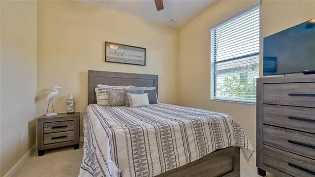 a bedroom with a bed a dresser and a window