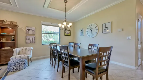 a dining room with furniture a chandelier and window