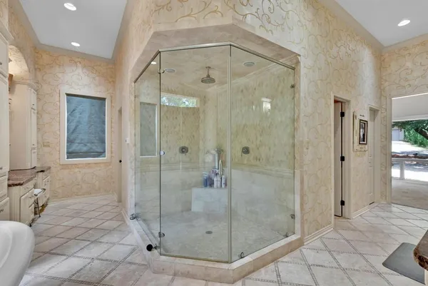 a spacious bathroom with a granite countertop sink a toilet a mirror and shower