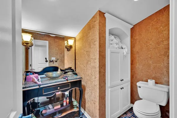 a bathroom with a granite countertop sink vanity mirror and toilet