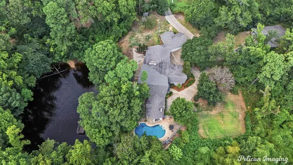 an aerial view of residential house with outdoor space and trees all around