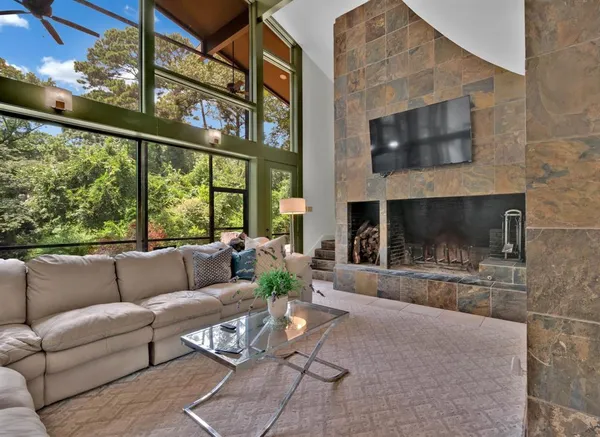 a living room with furniture a flat screen tv and a fireplace