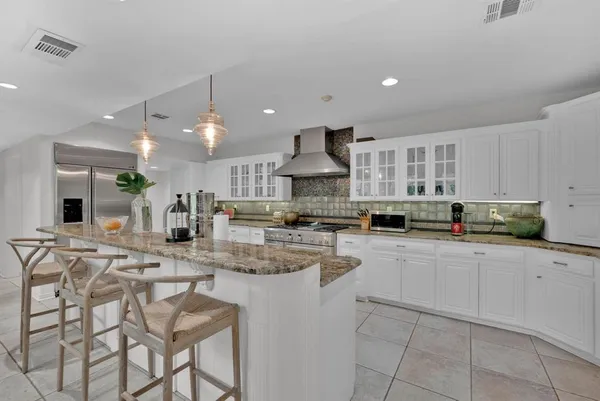 a kitchen with stainless steel appliances kitchen island granite countertop a sink and cabinets