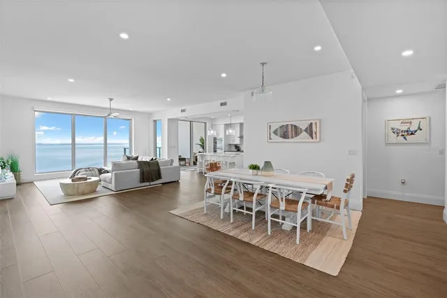 a living room with furniture large window and wooden floor