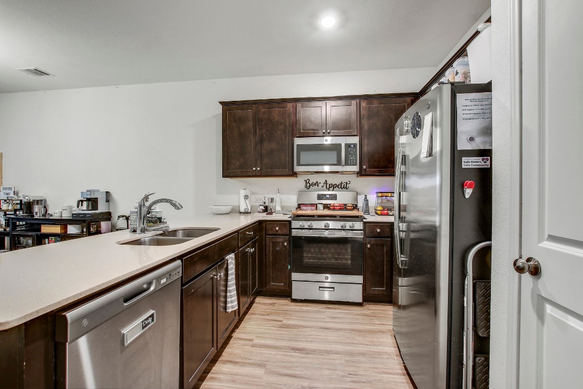 207 Soapstone Pass Maxwell, TX 78656 - Photo 14 of 30 a kitchen with stainless steel appliances a sink stove refrigerator and cabinets