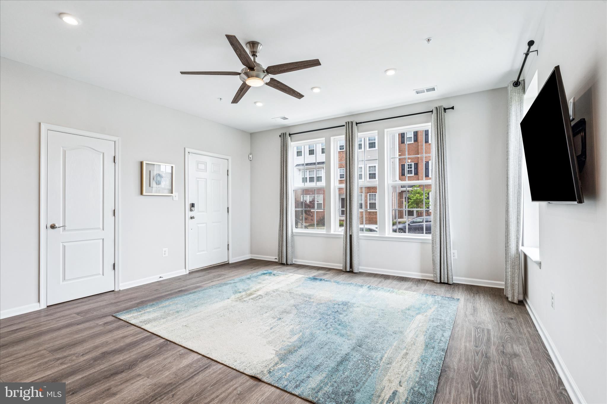 9454 James Macgowan Lane, Unit 447 Owings Mills, MD 21117 - Photo 4 of 41 a view of an empty room with wooden floor and a window