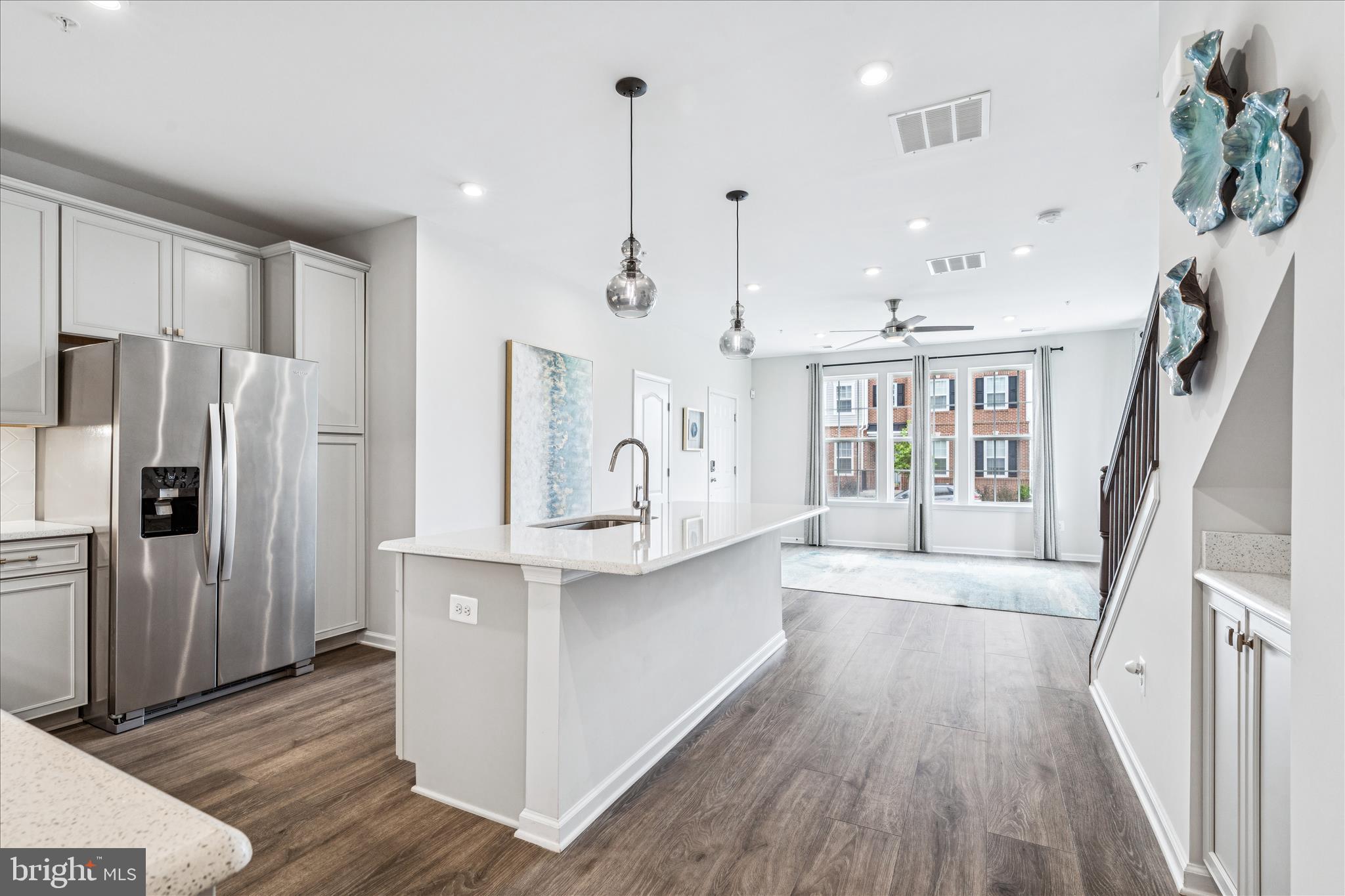 9454 James Macgowan Lane, Unit 447 Owings Mills, MD 21117 - Photo 8 of 41 a kitchen with stainless steel appliances granite countertop a refrigerator a sink dishwasher a stove and a dining table with wooden floor