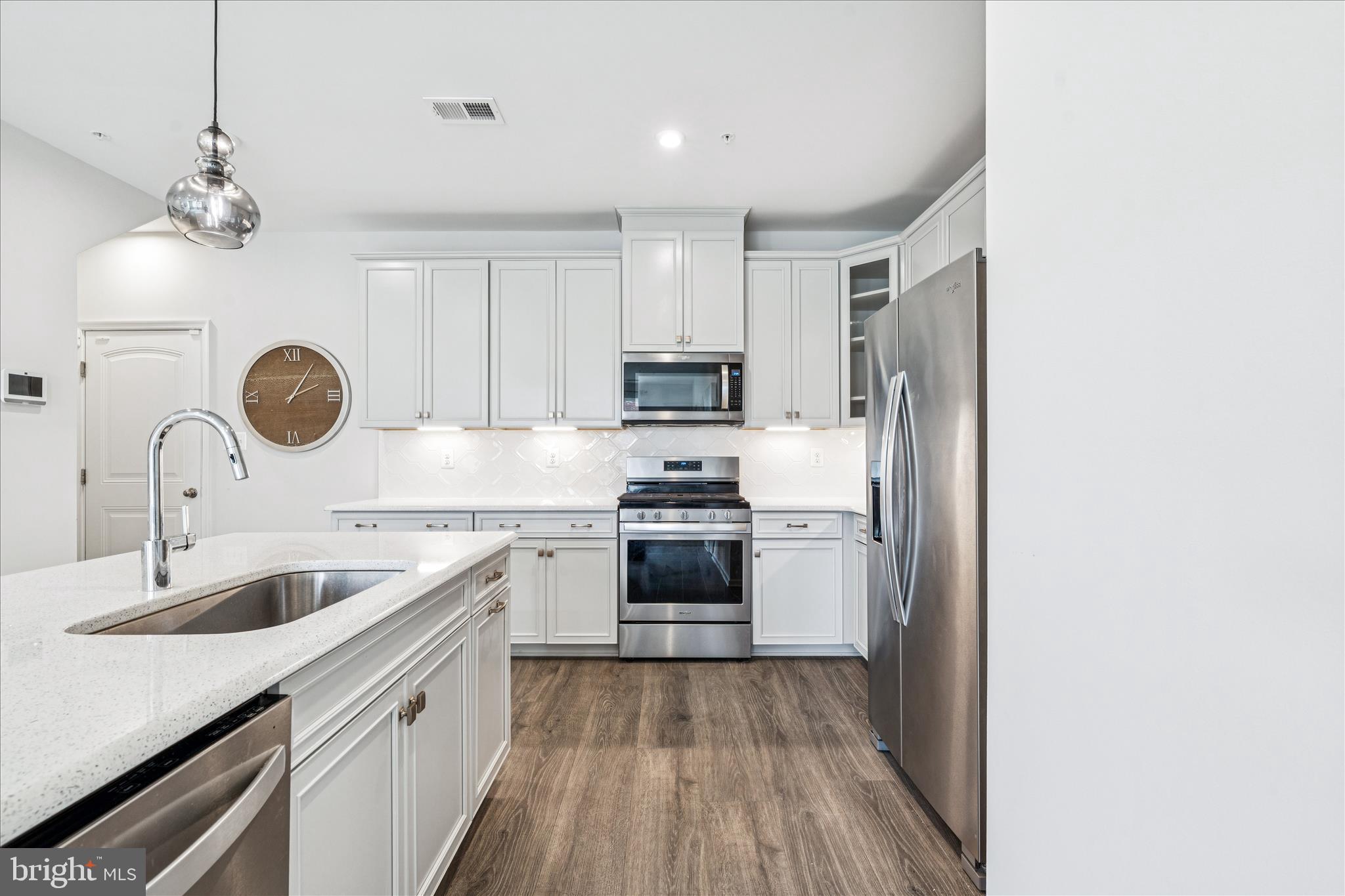9454 James Macgowan Lane, Unit 447 Owings Mills, MD 21117 - Photo 10 of 41 a kitchen with a sink dishwasher a stove and a refrigerator with wooden floor