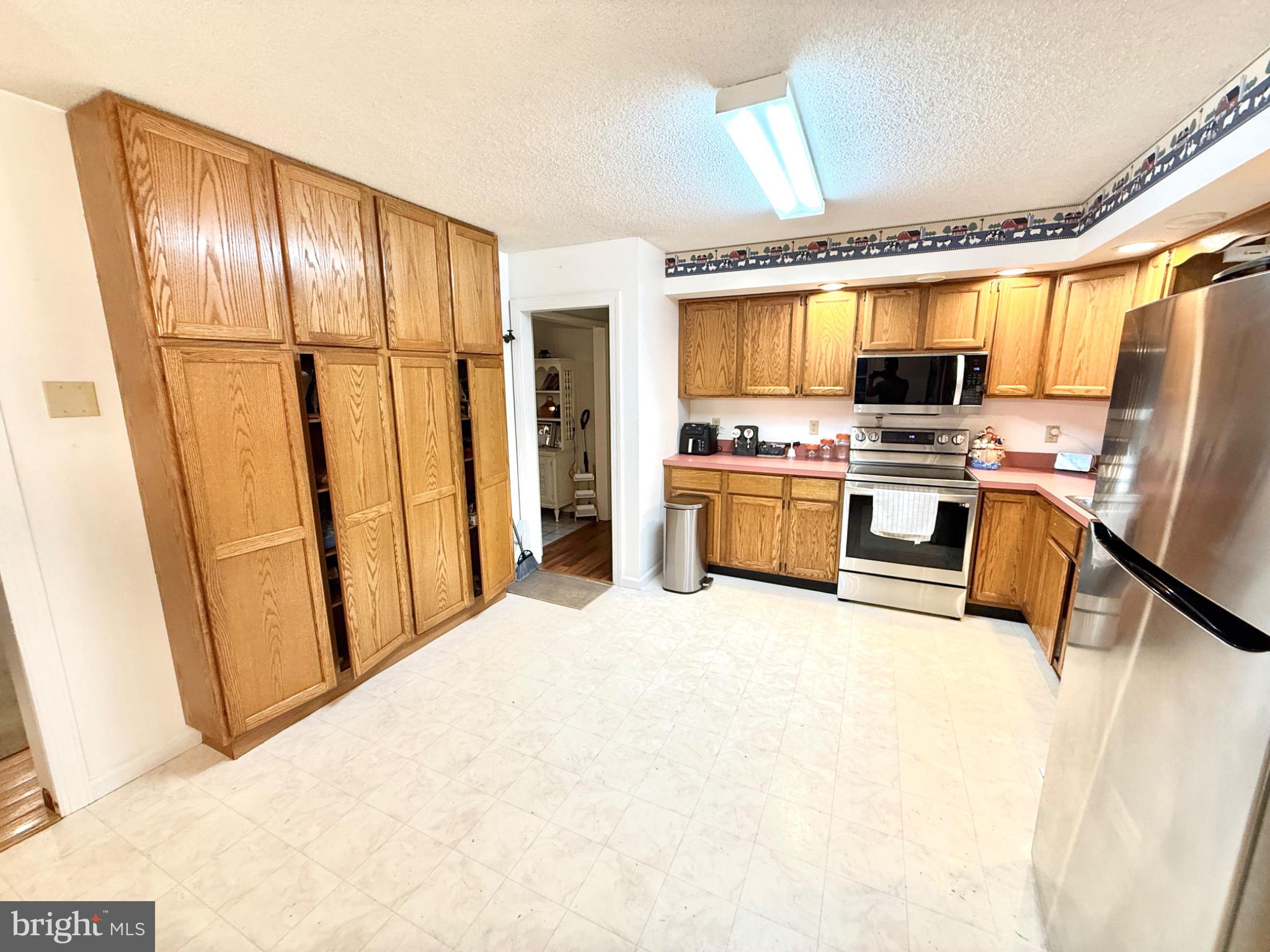 30772 River Road Laurel, DE 19956 - Photo 5 of 21 a large white kitchen with stainless steel appliances granite countertop a refrigerator and a stove top oven