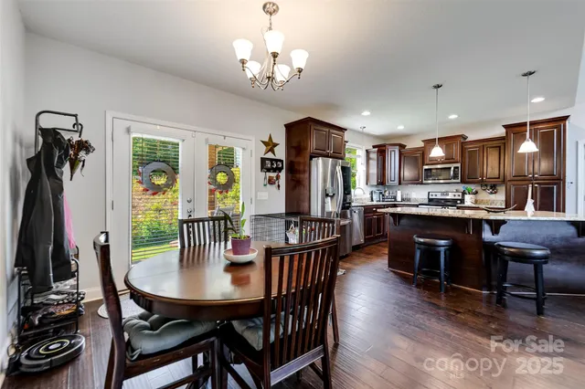a kitchen with stainless steel appliances kitchen island granite countertop a stove refrigerator and cabinets