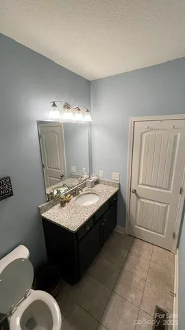 a spacious bathroom with a granite countertop sink a toilet and a mirror