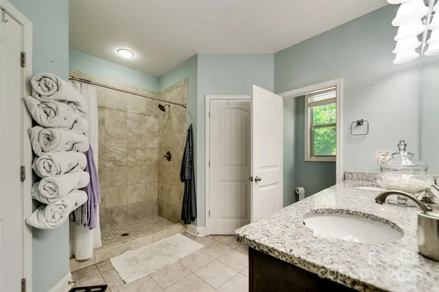 a bathroom with a granite countertop sink a mirror and a shower