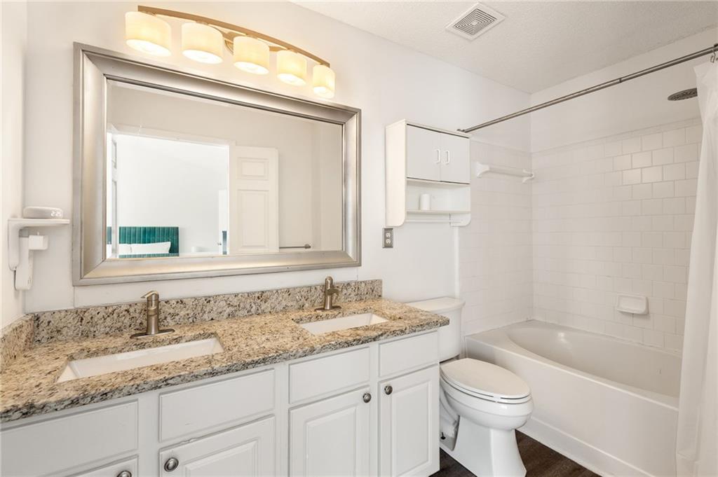 5750 Reps Trace Norcross, GA 30071 - Photo 12 of 18 a bathroom with a granite countertop sink a toilet and a bathtub