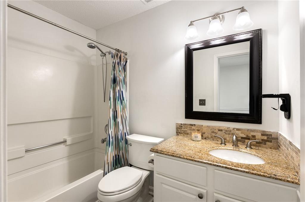 5750 Reps Trace Norcross, GA 30071 - Photo 14 of 18 a bathroom with a granite countertop sink toilet mirror and shower