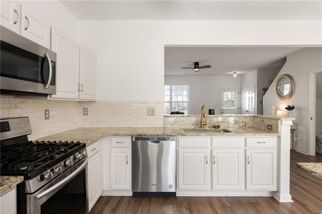 5750 Reps Trace Norcross, GA 30071 - Photo 7 of 18 a kitchen with granite countertop white cabinets and stainless steel appliances