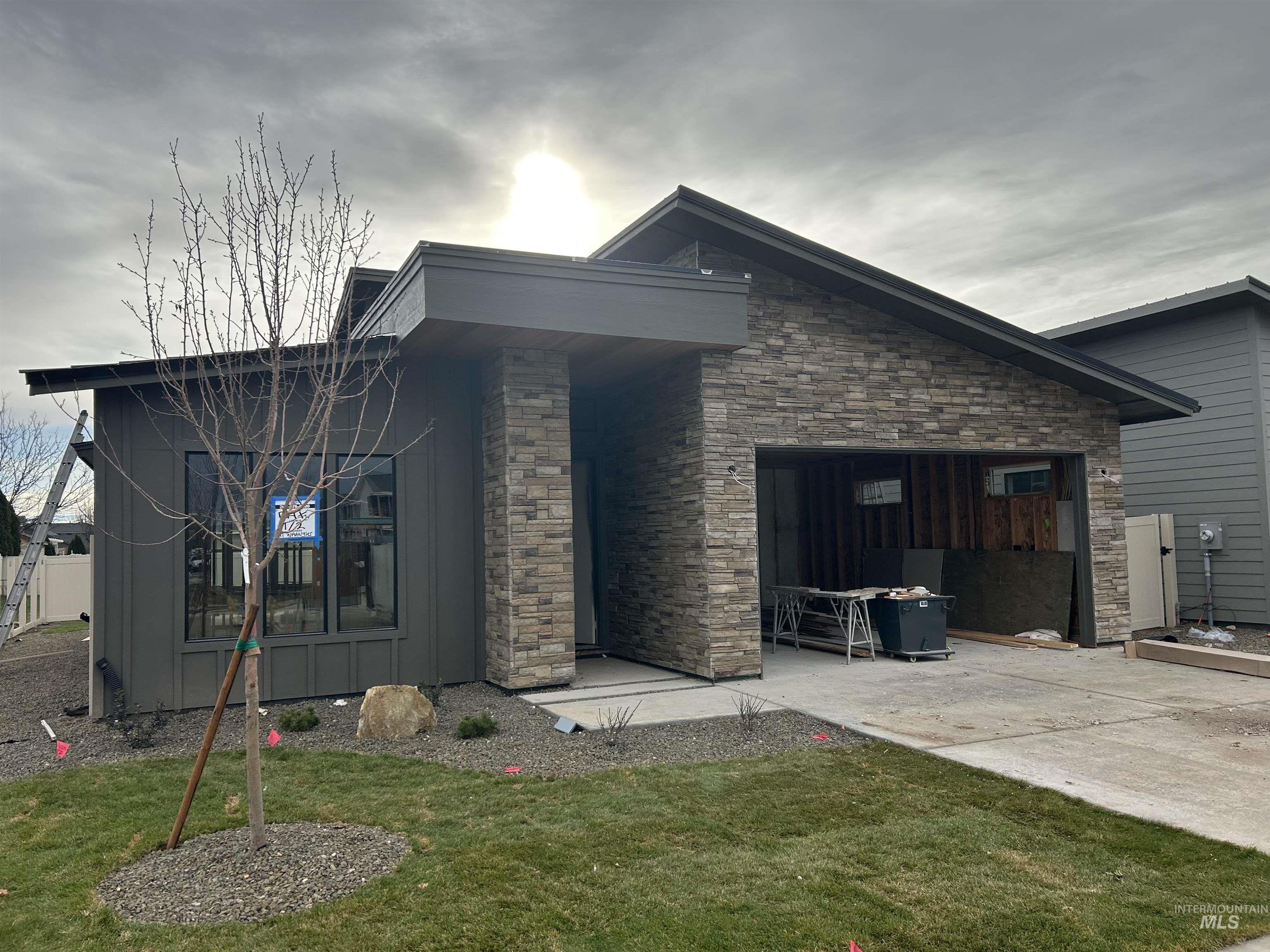 View of front facade featuring a front lawn and stone siding