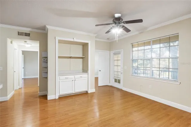 a view of an empty room with window and wooden floor