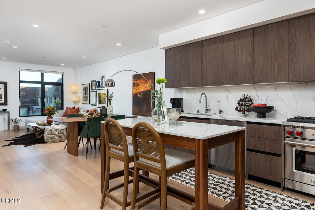 399 East Del Mar Boulevard, Unit 308 Pasadena, CA 91101 - Photo 2 of 32 a kitchen with a table chairs stove and cabinets