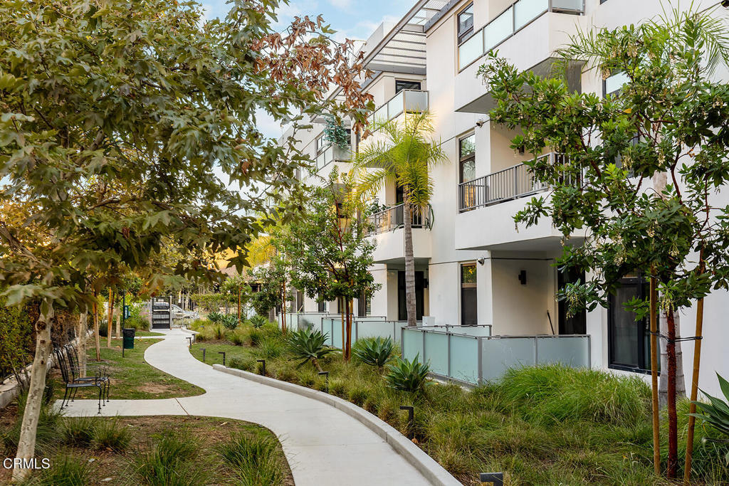 399 East Del Mar Boulevard, Unit 308 Pasadena, CA 91101 - Photo 25 of 32 a view of a white house next to a yard with plants and trees