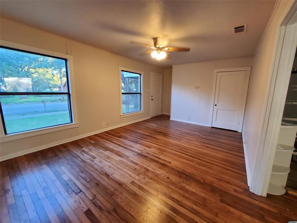919 South Clements Street Gainesville, TX 76240 - Photo 2 of 11 a view of an empty room with wooden floor and a window
