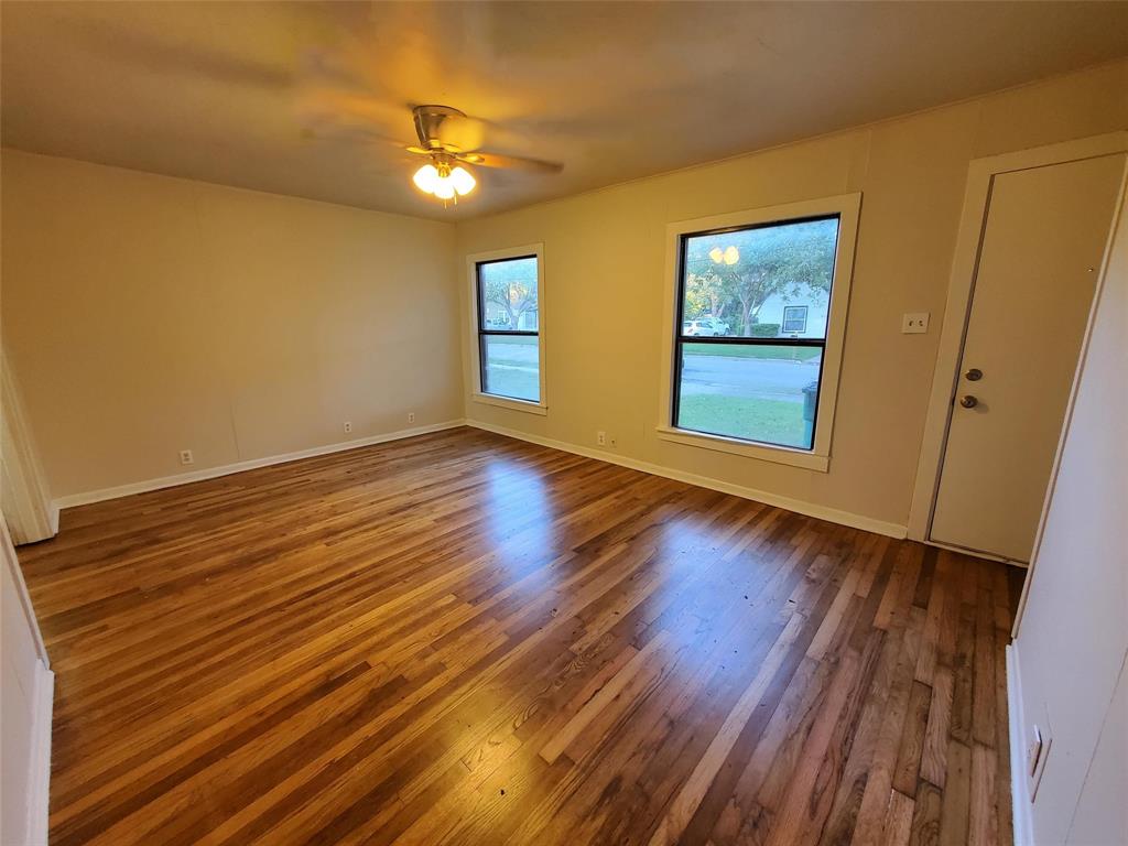 919 South Clements Street Gainesville, TX 76240 - Photo 3 of 11 a view of an empty room with wooden floor and a window