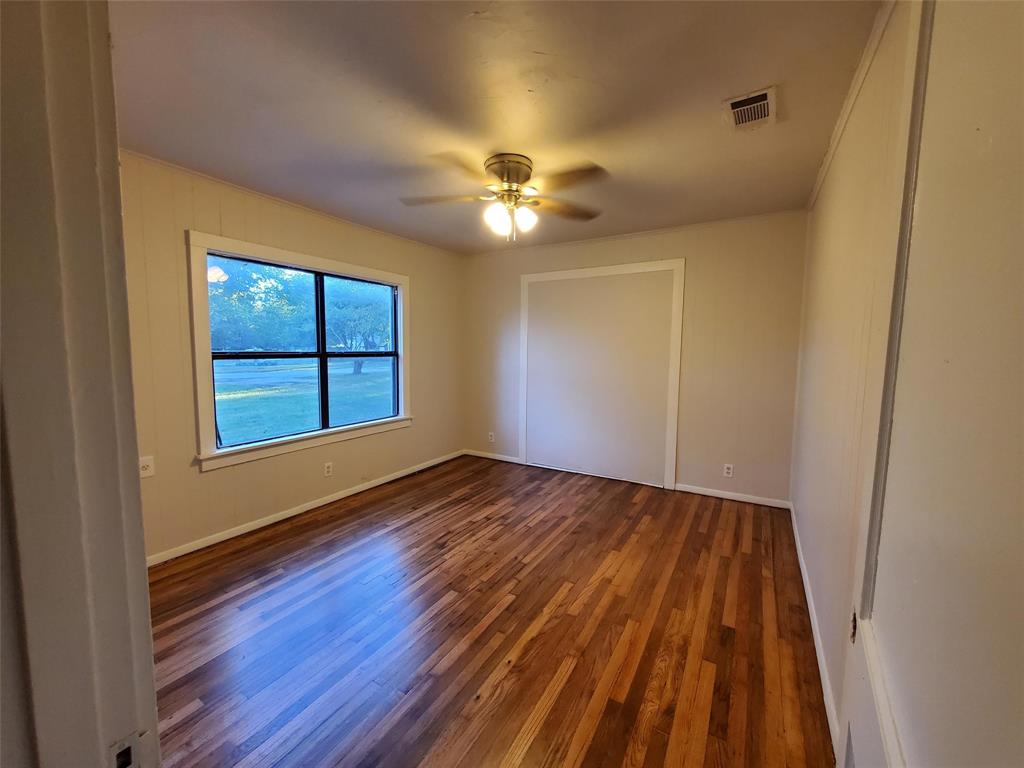 919 South Clements Street Gainesville, TX 76240 - Photo 7 of 11 a view of empty room with wooden floor and fan