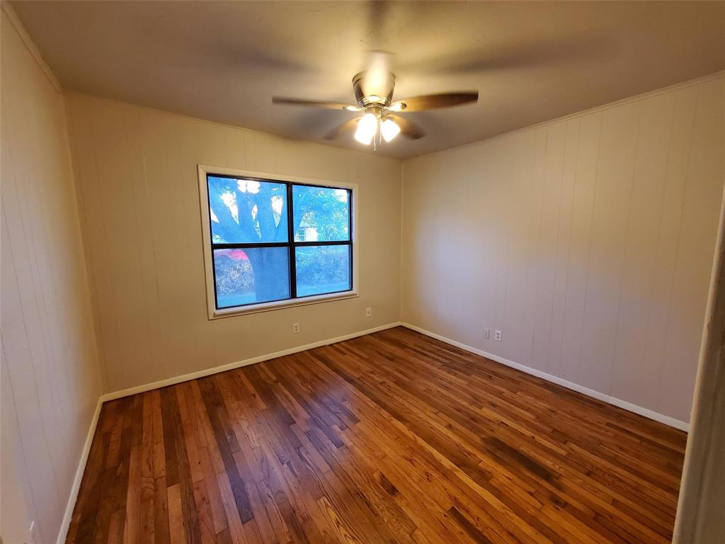 919 South Clements Street Gainesville, TX 76240 - Photo 8 of 11 a view of empty room with wooden floor and fan