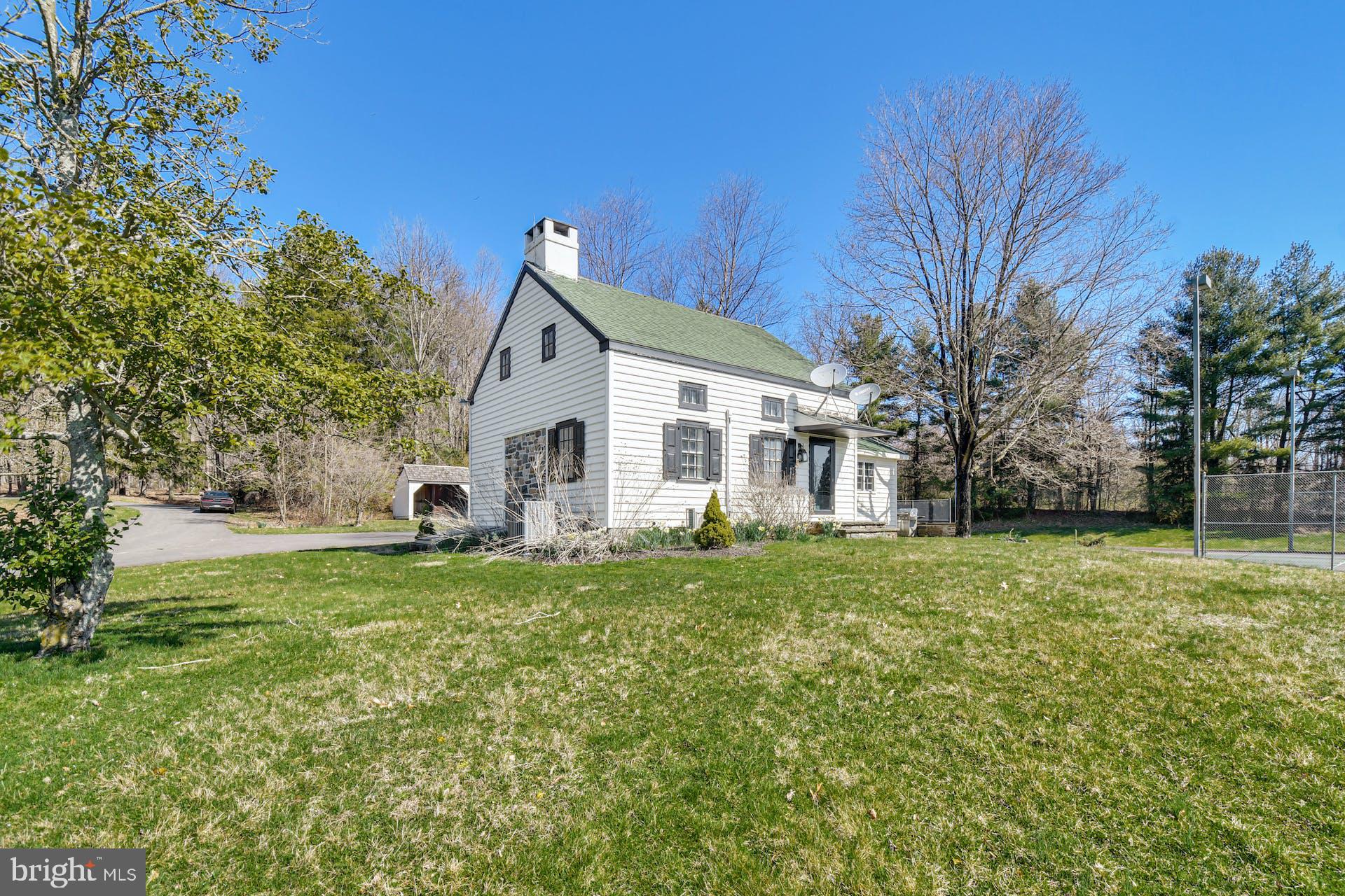 a view of a house with a big yard and large trees