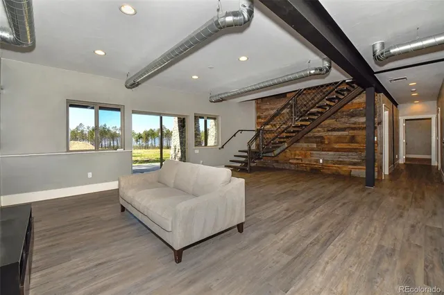 a living room with wooden floor furniture and a ceiling fan