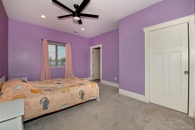 a bedroom with a bed chandelier and a window