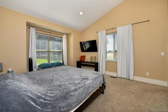 a bedroom with a bed and a flat tv screen on dresser