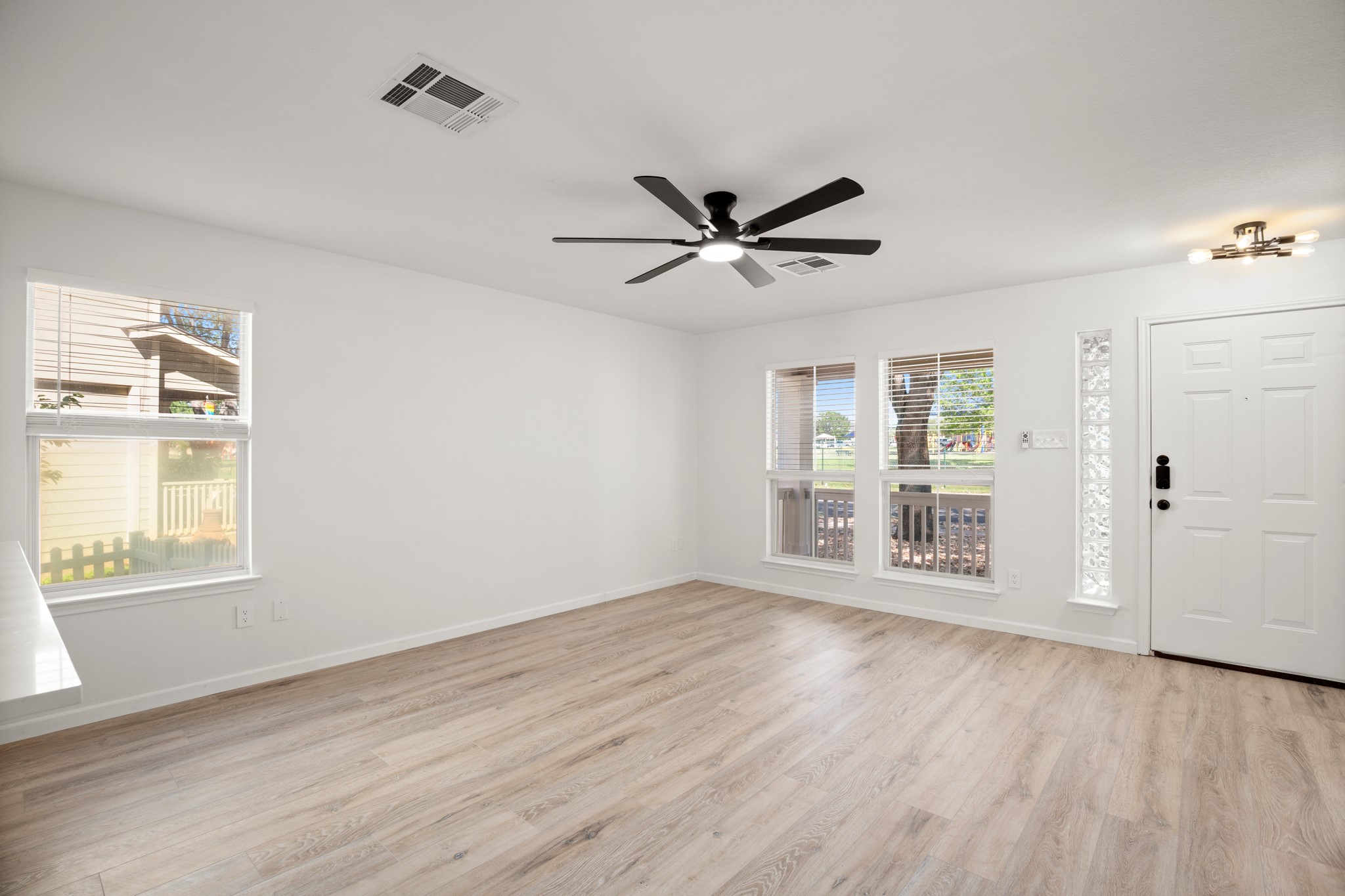 360 Sampson Kyle, TX 78640 - Photo 8 of 36 Open living area featuring wood-finish flooring, multiple windows, a modern ceiling fan, and recessed lighting